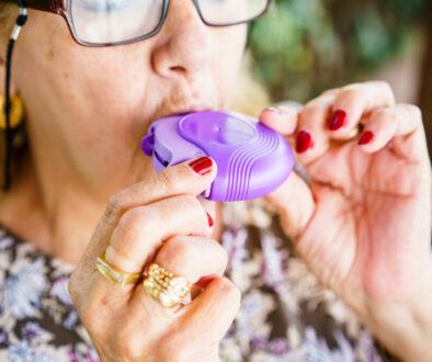 Senior woman breathing through inhaler